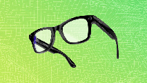 A pair of black smart glasses with built-in cameras and sensors, floating against a green and yellow gradient grid background.