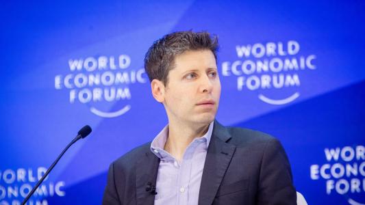 A man sitting in front of a microphone at the world economic forum.