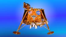 Gold lunar lander model with NASA and flag decals on a blue gradient background.
