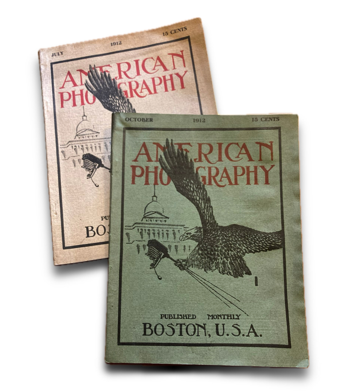 Two vintage issues of "American Photography" magazine from 1912, featuring illustrated covers with an eagle and the U.S. Capitol dome, published in Boston, Massachusetts.