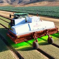 a tractor with a green light in the middle of a field.