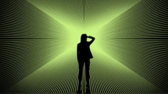 Silhouette of a person standing in front of a bright green, radial light pattern creating an optical illusion effect.