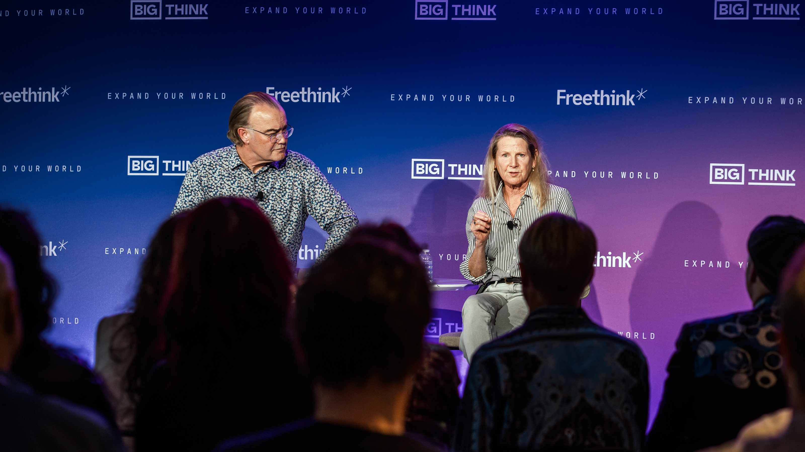 Two speakers sit on stage engaging with an audience during a panel discussion at a Freethink and Big Think event.