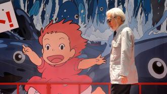 A person strolls past a large mural showcasing an animated character reminiscent of a Studio Ghibli creation, with red hair and a pink dress against a blue background.